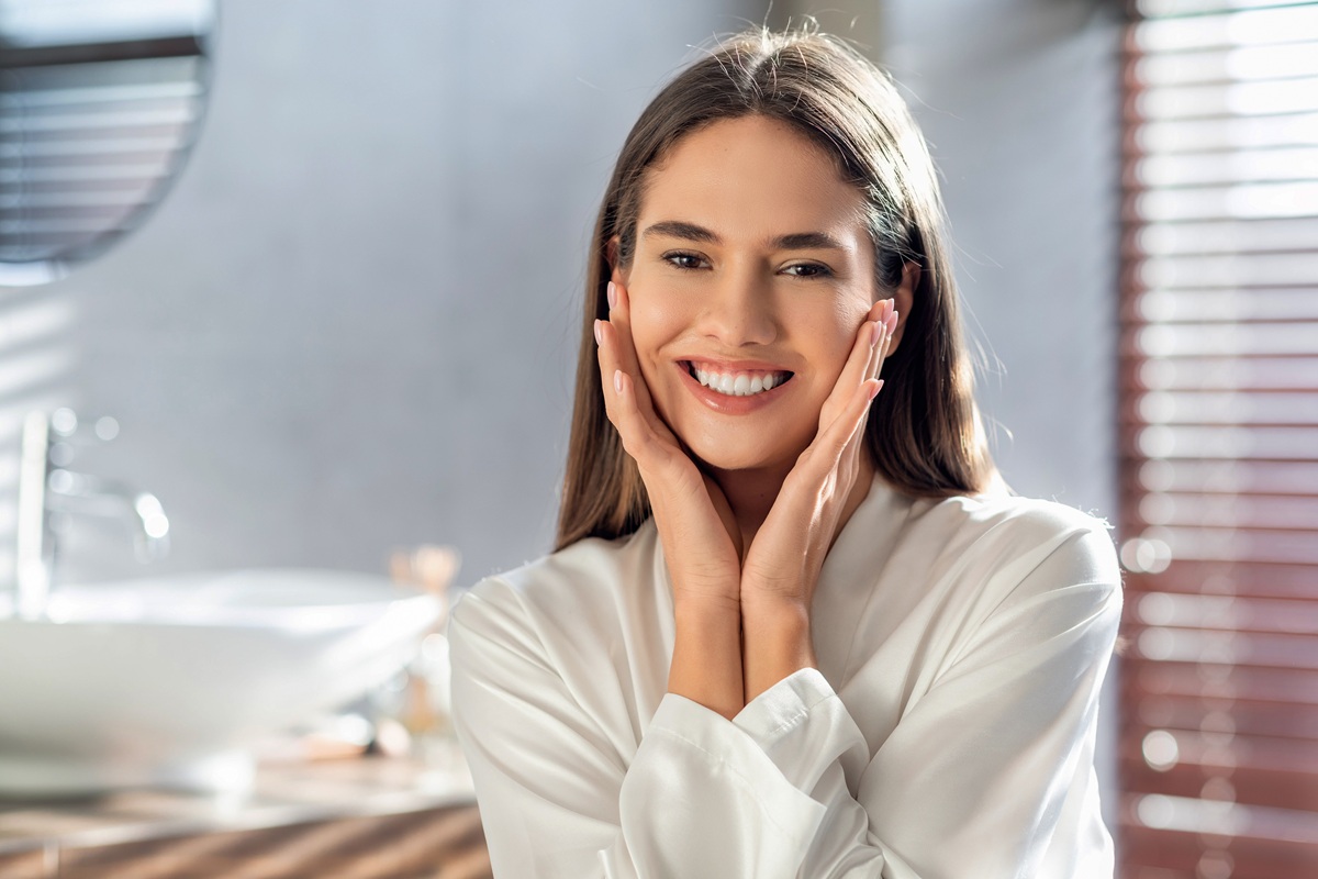 Woman smiling confidently after cosmetic dental treatment